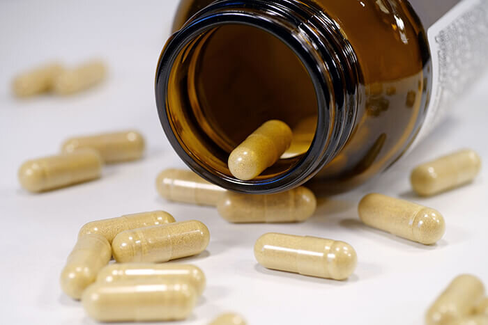 SUNLIFE Nature Nahrungsergänzungsmittel - Glas, aus dem Kapseln ausgekippt werden.